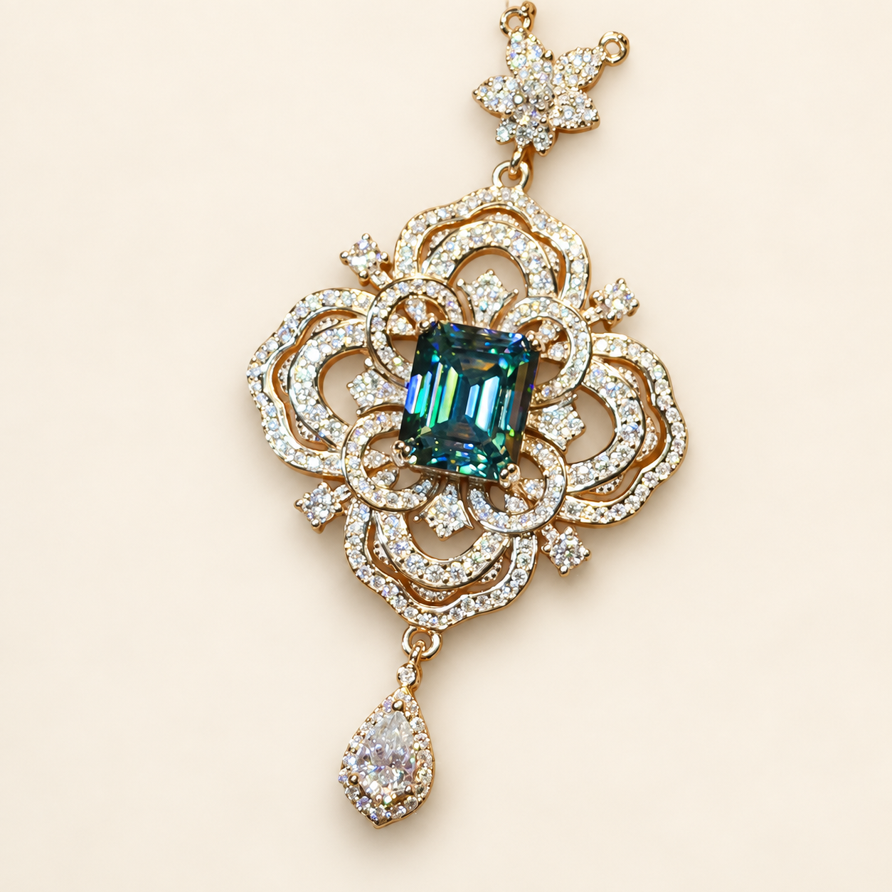 Style reference: ornate gold-tone scroll pendant with a blue-green center stone